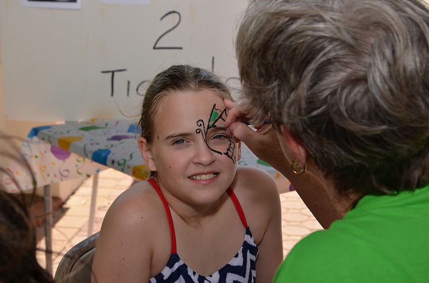 Annalise Love has a butterfly painted on her face.