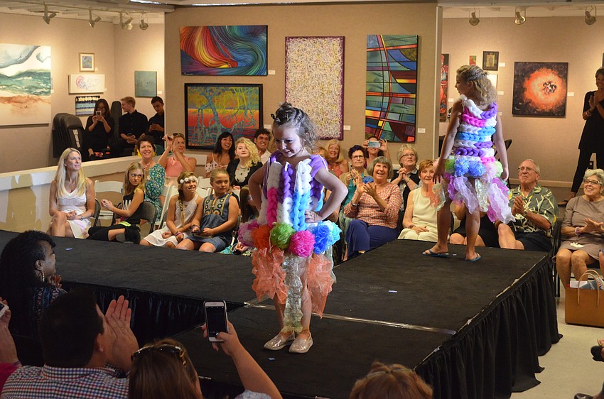Holland Anders, 5, smiles for the sea of iPhone cameras while her sister, designer Cambelle Anders, 9, does the same for the other side of the runway. The big sister created “Sassy Sponge Sisters” using bath sponges/loofahs and hair elastics.