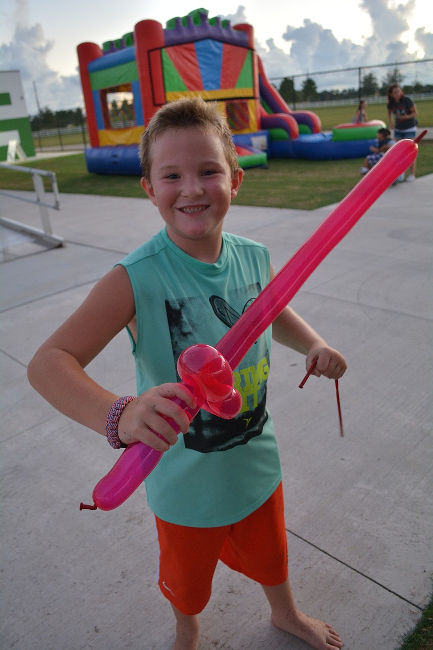 Eli Graham, 6, of Heritage Harbour, shows off his balloon sword. He also couldn't figure out how magician Stevie Dee was able to blow the balloons up. He couldn't do it.