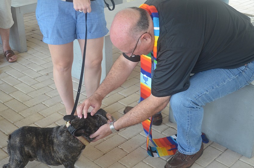 Reverend Wayne Farrell blesses Dewey, a french bulldog.