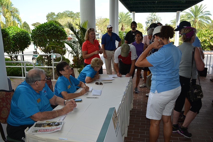 Those participating in the Elks tourney register before the event.