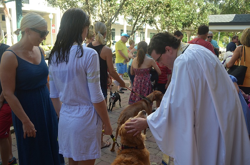 Father Charleston Wilson blesses Magic with Madeline Carson, 12.