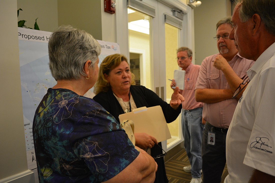Cheri Coryea, center, director of neighborhood services for Manatee County, talks with attendees about what the sales tax would do for the library system.