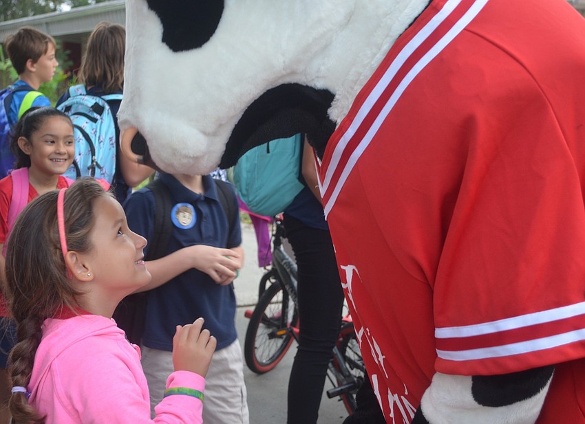 Nyla Shattuck, 5, eagerly looks up at the Chick-fil-A cow as he leans down to give her a big  hug.