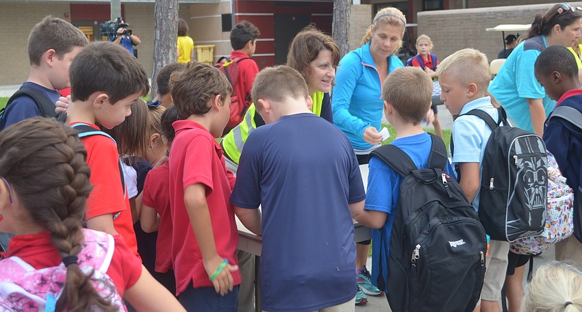 Students who participated in National Walk to School Day flood the tables to sign in.