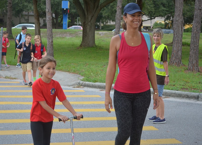 Braden Woods' Alice Abreu, 6, scooters alongside her mom, Julia Abreu, as they make it to school on National Walk to School Day.