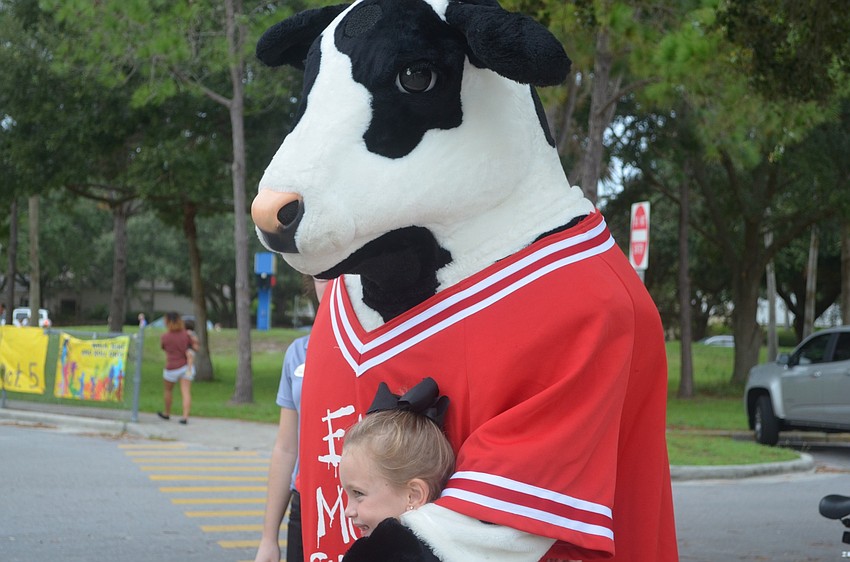 Lakewood Ranch's Sophia Potillo, 7, snuggles up next to the Chick-fil-A cow after walking to school for National Walk to School Day.