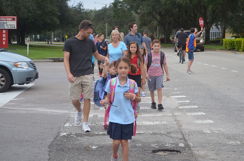 Emma Littlefield, a second-grader at Braden River Elementary, leads the pack as she safely uses the crosswalk.
