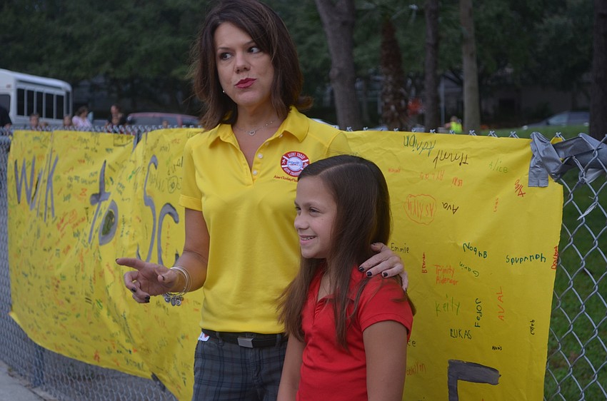 Melissa Wandall with Alert Today Florida stands with Tara's Rilyn Ferber, 10, as she talks about the importance of National Walk to School Day.