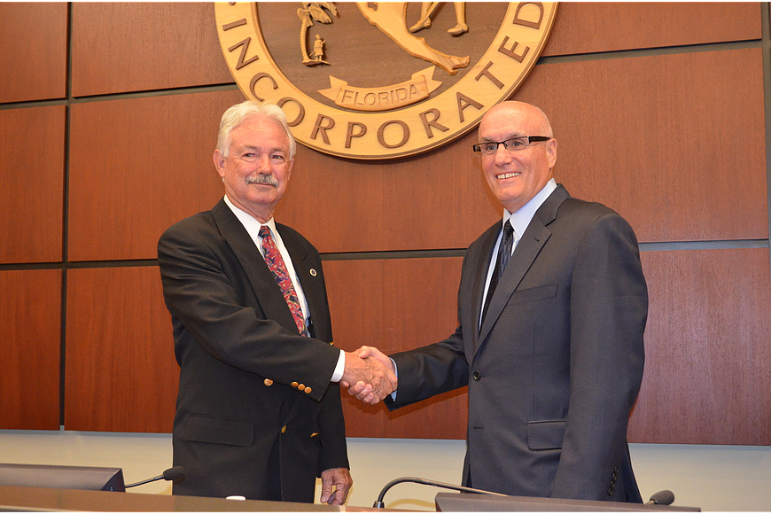 Jim Brown, left, shakes hands with Mayor Jack Duncan in the longboat Key Commission chambers.