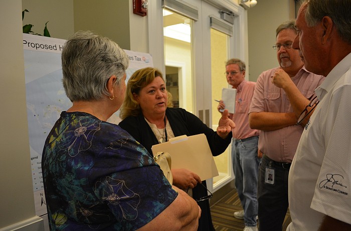 Cheri Coryea, Manatee County neighborhood services department director, center, talks with Chris Butch, left, and her husband, Joe Butch, far right.