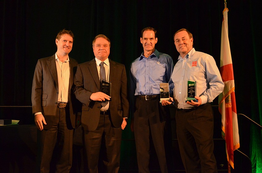 Wes Robers presents the awards for Attaining Milestone Anniversaries of Service to Jim Paulmann of Santec Consulting, Mark Byers of Florida Power & Light, and Tom Waters of Easter Seals Southwest Florida.
