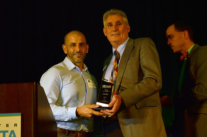 Raymond Menendez of Daily Eats receives an award for Hiring Our Neighbors from Jon Thaxton.