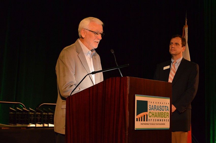 Joe H. Hembree leads the audience into the Pledge of Allegiance.