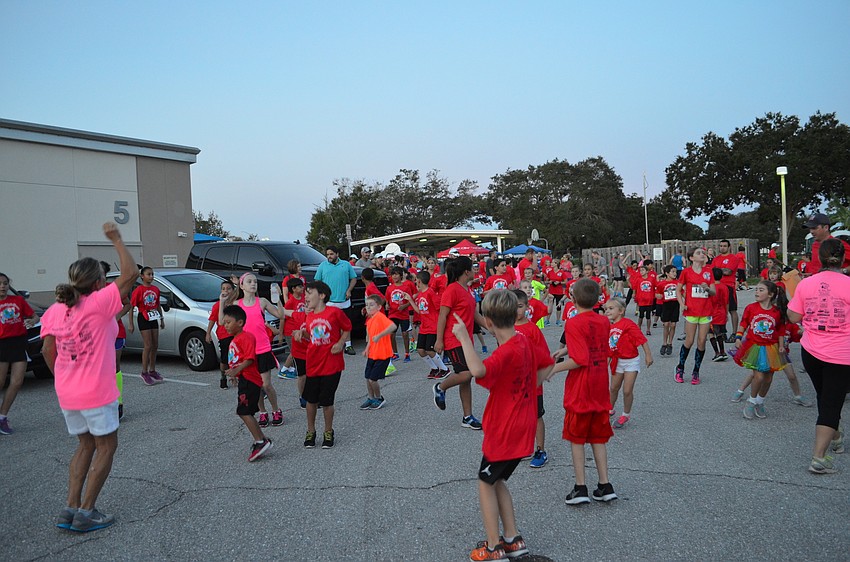 Wellness and Physical Education teacher Amy Kanter warms up students before the start of the 7K and 1-Mile Fun Run.