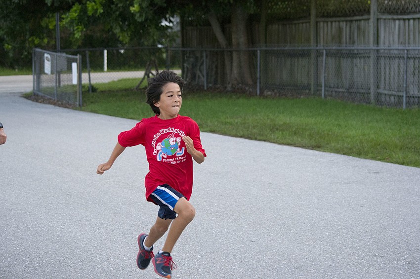 Noah Brum runs faster as he approaches the finish line for the 1-Mile Fun Run.