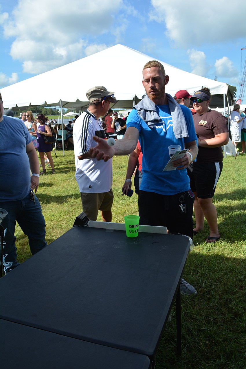 Matt Barber, of North Port, is disappointed with his aim during a beer pong-style game for prizes.