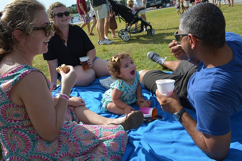 One-year-old Gabriela Jorge eagerly awaits a bit of slushy from her father, Jonatan Jorge, as her mom, Quinn, left, and friend Brigid Davidson, behind, watches.