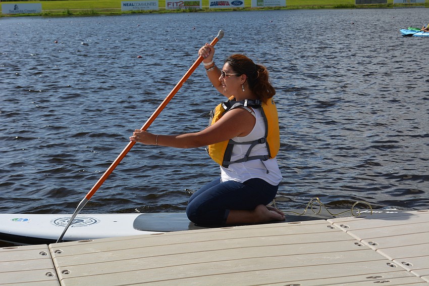 Nataly Solis, of Land O' Lakes, learns how to paddle board.