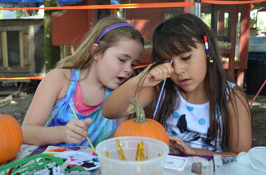 Cianna Desideri and Avery Caver brainstorm on how to decorate their pumpkins.