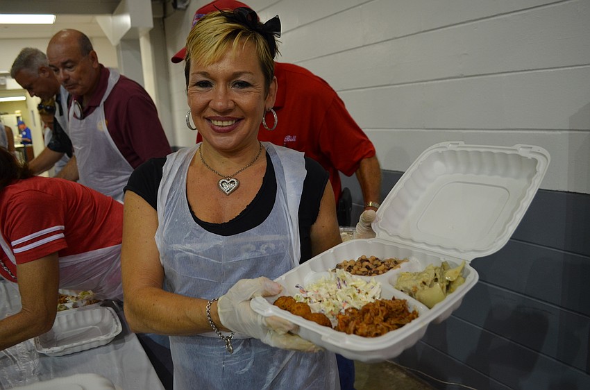 Volunteer Cay Kauffman helps fill boxed lunches with barbecue, coleslaw, black-eyed peas and swamp cabbage.