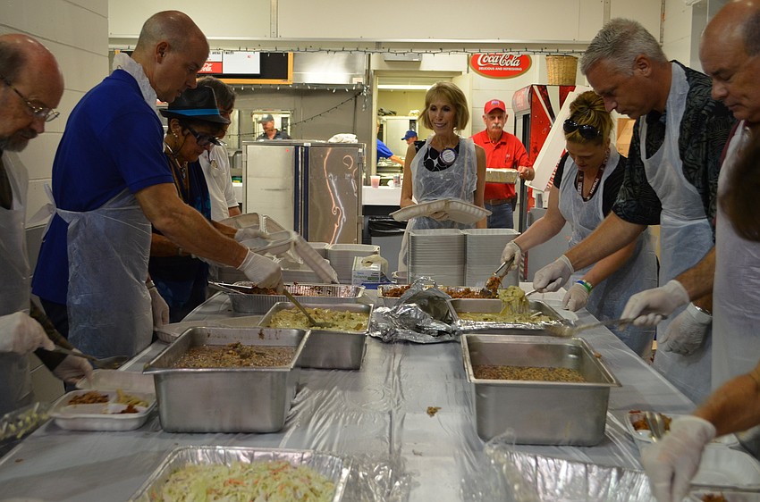 Volunteers helped to serve the 600 guests with boxed lunches that included the pioneer staple of swamp cabbage.