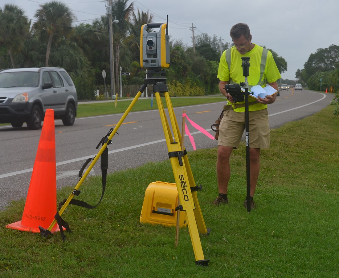 Hurricane Matthew kept up a steady drizzle Friday as surveyor crew chief Mike Wheeler, of Hyatt Survey Geographic Data Specialists of Bradenton, peered through his gear at the intersection of Cutter Drive and Gulf of Mexico Drive.