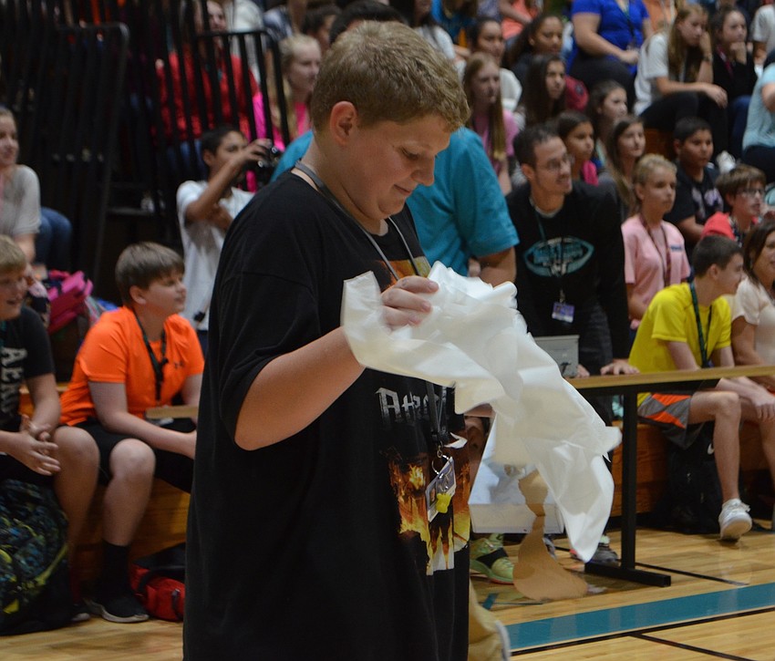 Seventh-grade student James Mamlock pulls tissue out of the box during a competition at Haile Middle School.