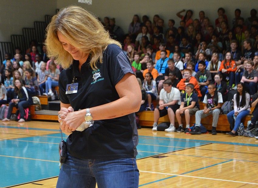 Principal Sharon Scarborough puts every ounce of strength into unraveling the frozen T-shirt during 