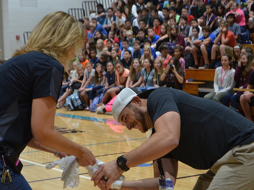 Principal Sharon Scarborough and physical education teacher Kent Delayer work together as a team as students watch them try to break apart the frozen T-shirt during an 