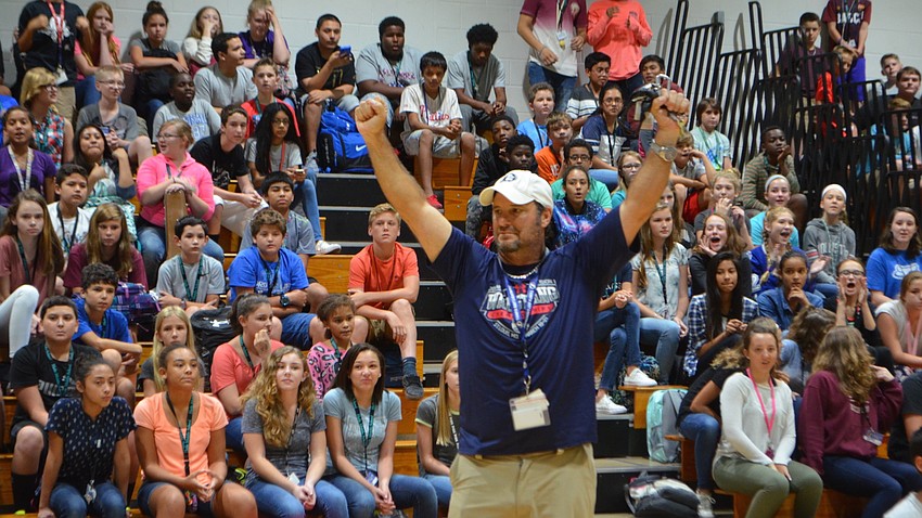 Teacher Andrew Gugliemini celebrates after the students finish the hula hoop competition at Haile Middle School.