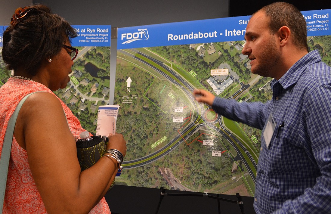 Mill Creek's Valerie Cooper-Miller listens as Jeff Mednick, a FDOT project manager for design, shows her what the roundabout would look like.