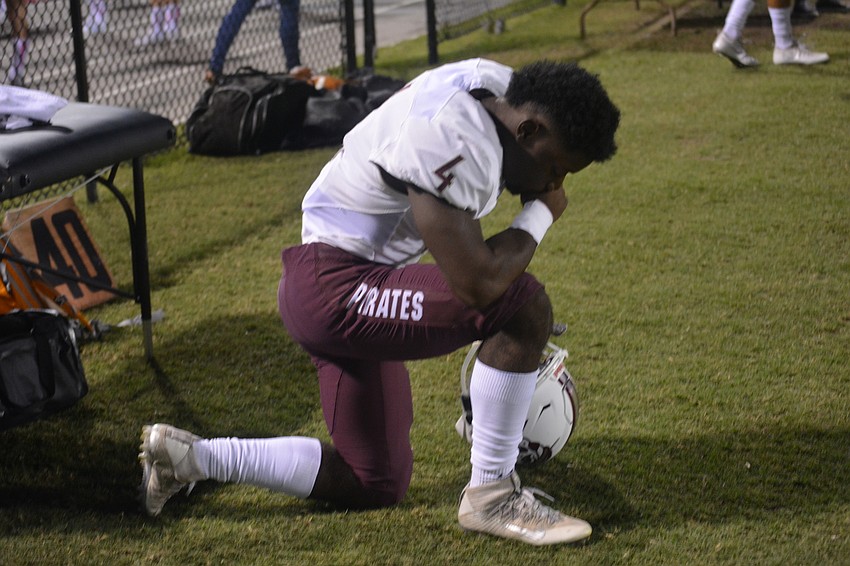 Braden River running back Raymond Thomas kneels prior to his team's game against Venice. The Pirates lost 42-35.