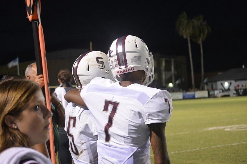 Braden River senior defensive back Demetrius Lawson puts his arm around fellow senior defensive back Tyrone Collins during the first half of their game against Venice.