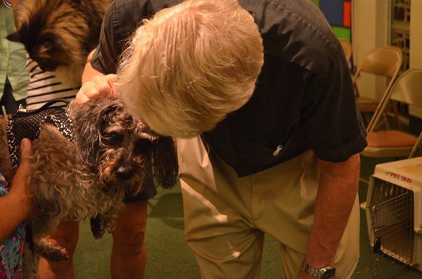 Pastor Eric Wogen blesses Gracie, a 10-year-old schnoodle, during St. Armands Key Lutheran Church’s annual pet blessing.