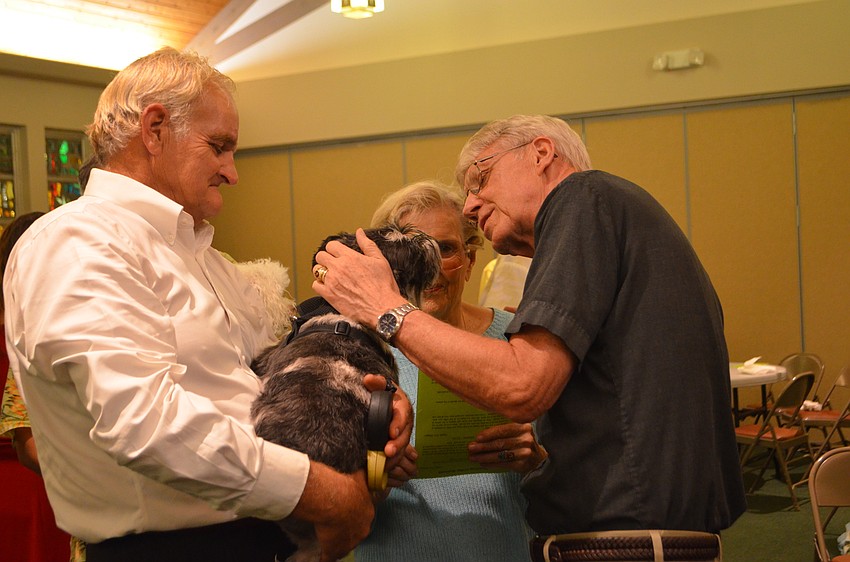Pastor Eric Wogen blesses Clue, 5, with help from Craig Snyder.