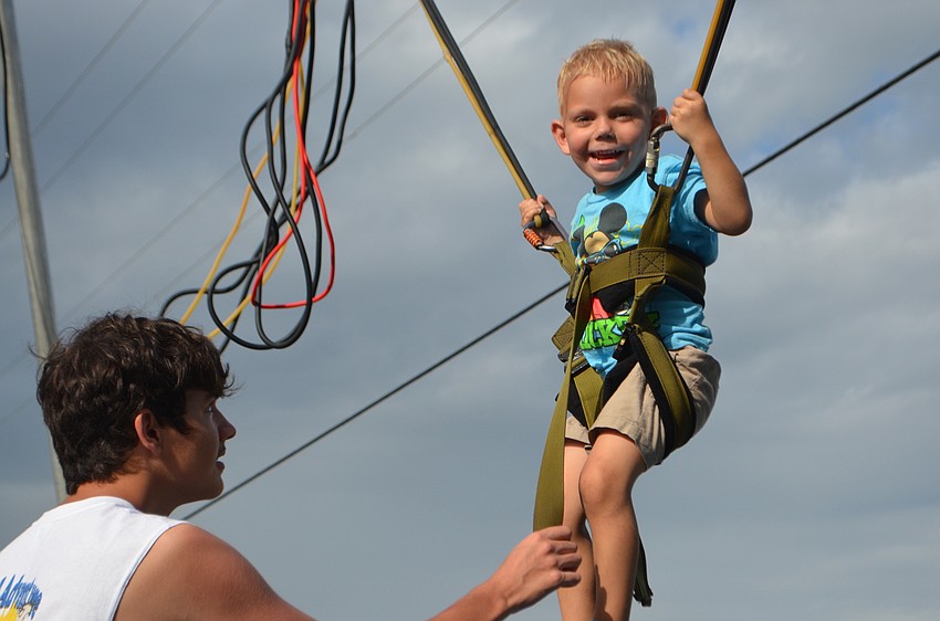 Tampa's Eric Tucker makes sure Venice 4-year-old Allen Lauterbach is safe to begin a bungee jump.