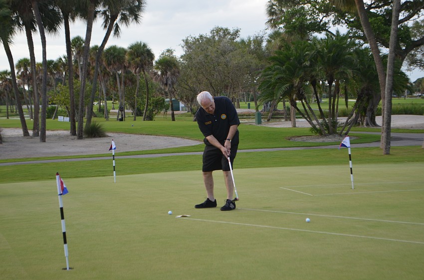 Commissioner Irwin Pastor practices his putt before the putting challenge on Oct. 15.