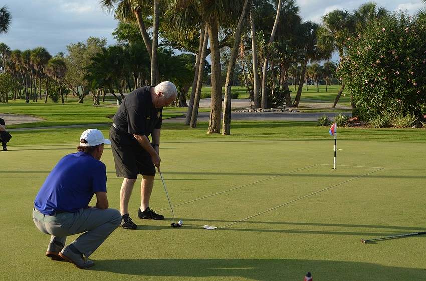 Golf director for the Longboat Key Club Terry O’Hara helps Irwin Pastor during the OPL Putting Challenge.