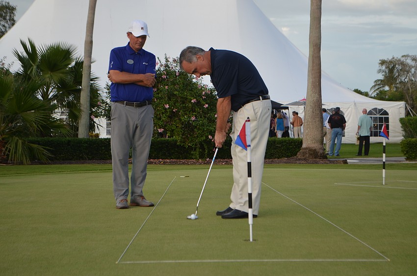 Andy Berger, vice president of Ocean Properties Ltd., putts while Terry O’Hara watches.