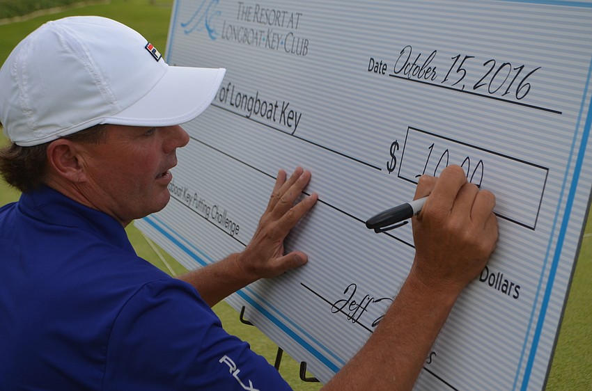 Terry O’Hara, golf director for the Longboat Key Club, writes out the $10,000 check to the town of Longboat Key for the Bayfront Park revitalization.