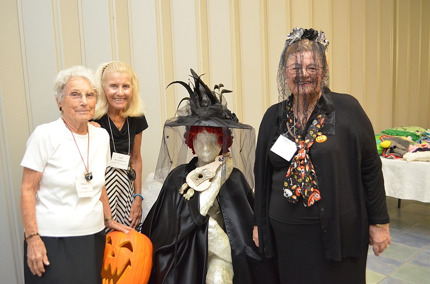 Stella Kelley, Gail Buermann and Andy Youngs stand with a decorated statue at St. Mary Star of the Sea Women’s Guild Welcome Back Luncheon.