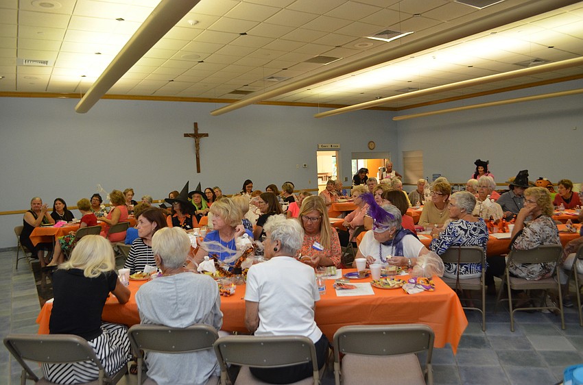 Guests listen to Rev. Gerry Finegan as he welcomes them back to the church.