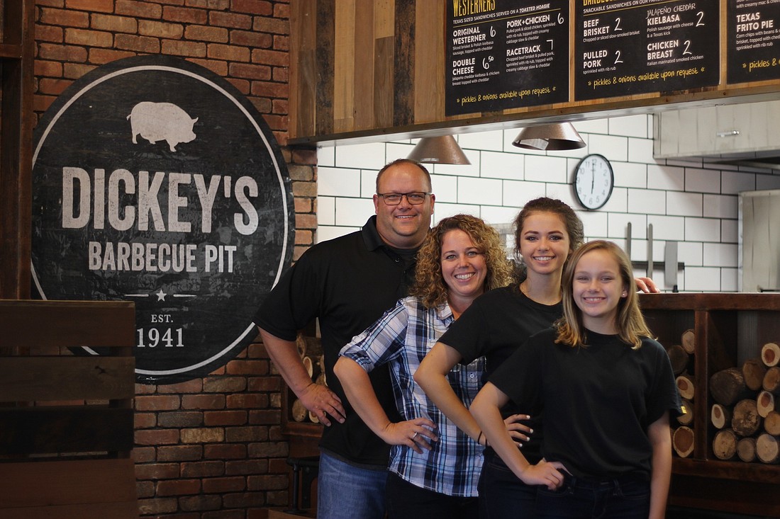 Dan and Pam Wood, owners of the new Dickey's Barbecue Pit location, stand in their new restaurant  with their two daughters, Lauren and Kaitlyn. The restaurant will open Thursday, Oct. 20.