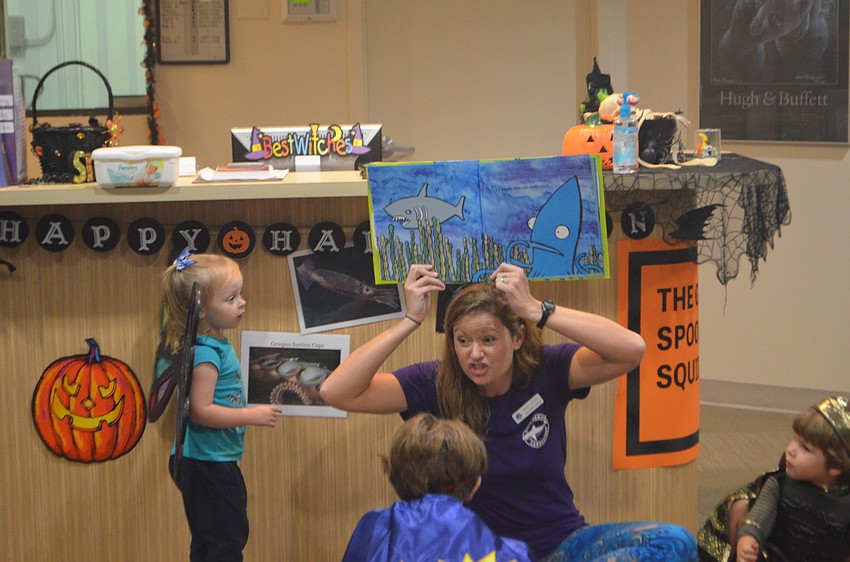 Mandy Wrobel, Senior Public Program Coordinator for Mote, reads a book to guests during a Mommy and Me session at Mote’s Night of Fish, Fun and Fright.