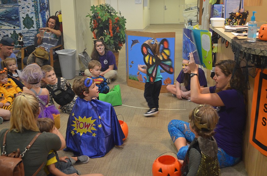 Mandy Wrobel, Senior Public Program Coordinator for Mote, reads a book to guests during a Mommy and Me session at Mote’s Night of Fish, Fun and Fright.