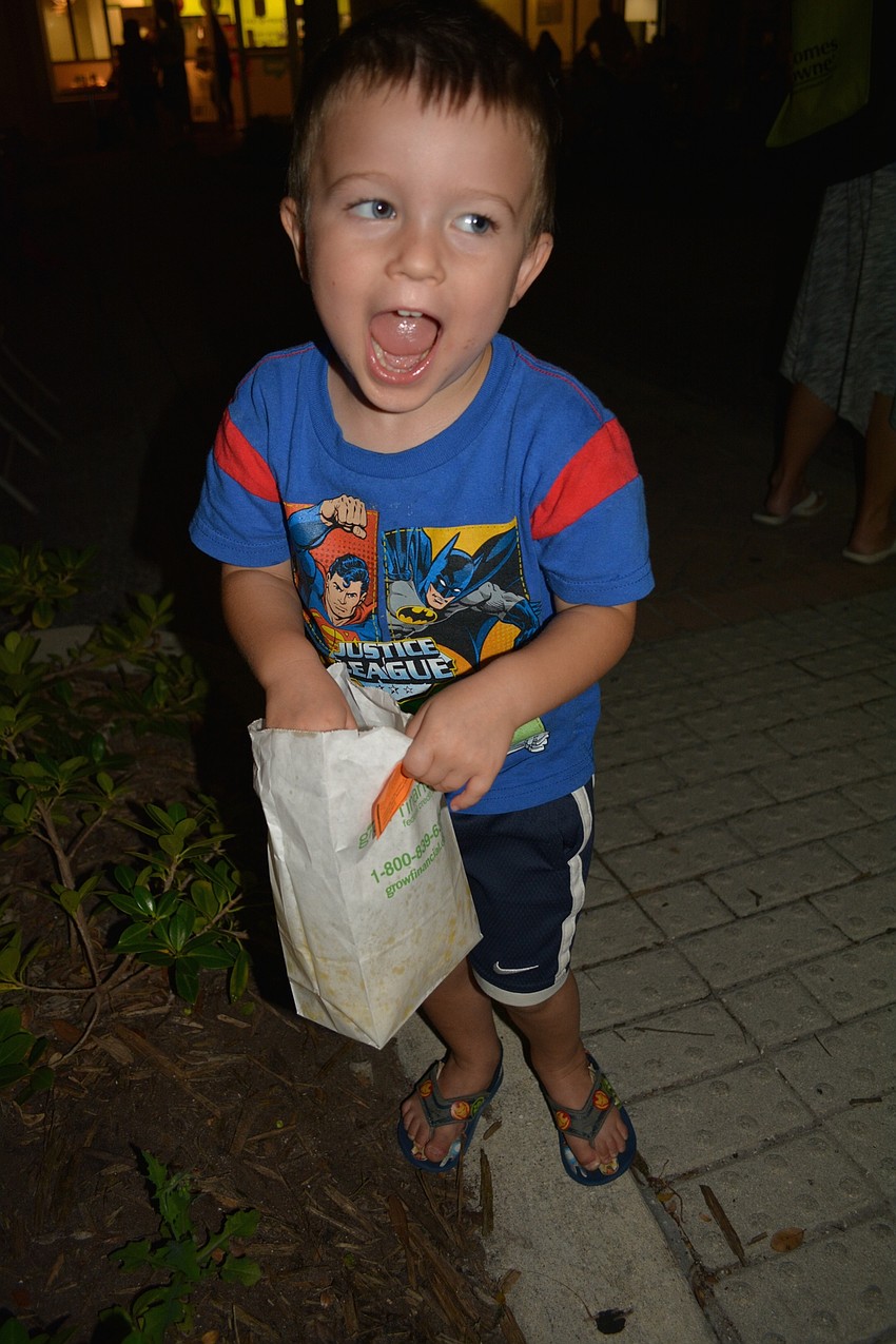 Lakewood Ranch's Elliott Eubanks, 3, munches on popcorn while dancing to music at the block party.