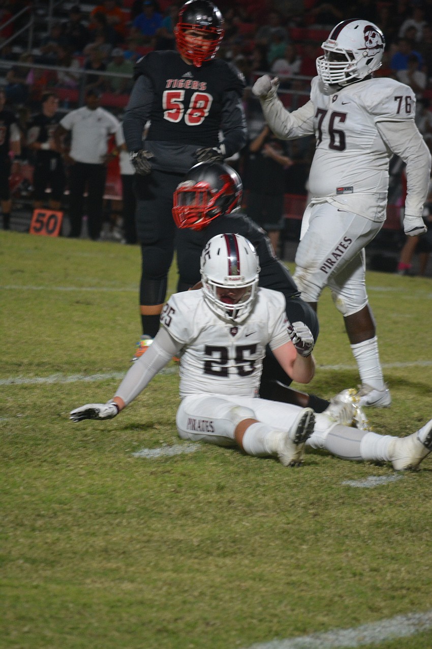 Braden River defensive end Chase Knopf sits and fist pumps after making a tackle on Oct. 21 against Palmetto. The Pirates won the game 35-0.