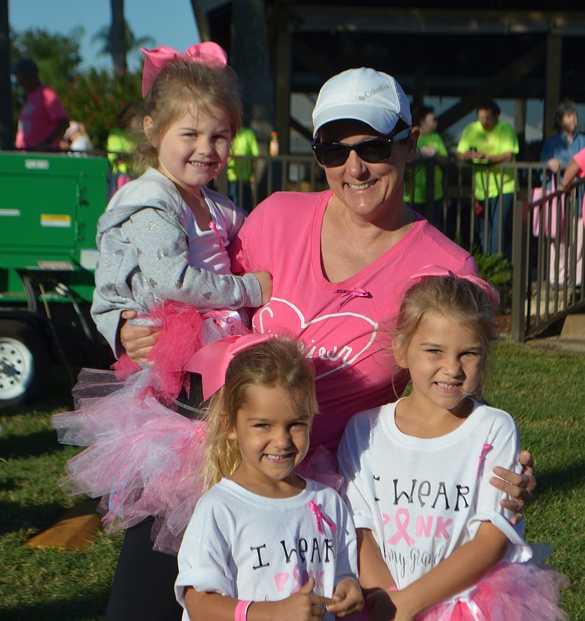 In back, 3-year-old Corrine Kitcher is held by Lisa Chives. In front, Madison Johnson and Lillian Johnson wear matching tutus to support breast cancer awareness.