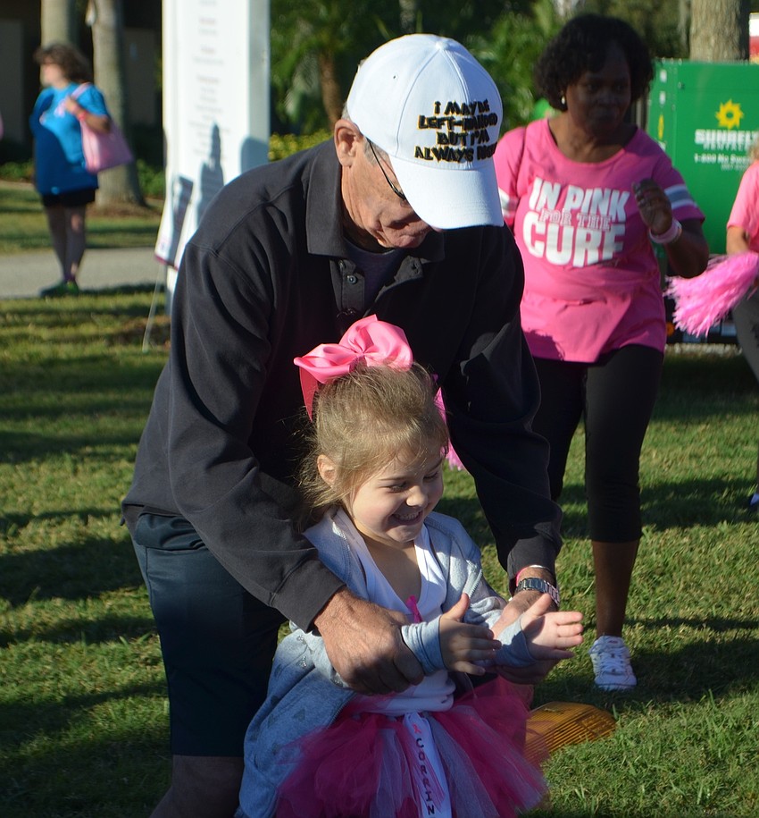 Bradenton's Roger Marquis, 76, helps his great granddaughter Corrine Kitcher, 3, clap during a dance at the Making Strides Against Breast Cancer Walk.